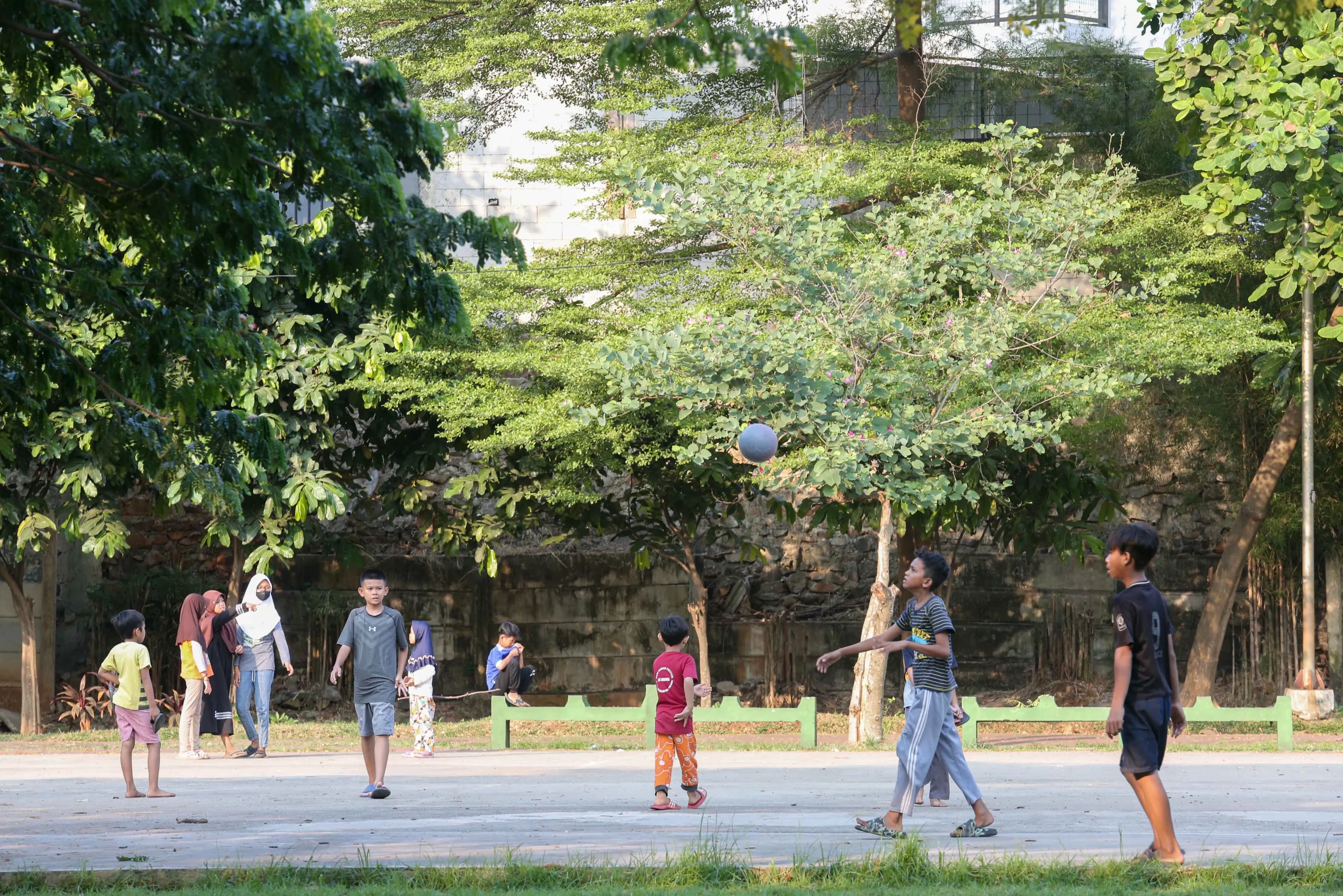 Keluarga berjalan di taman perumahan hijau Bogor menikmati udara bersih