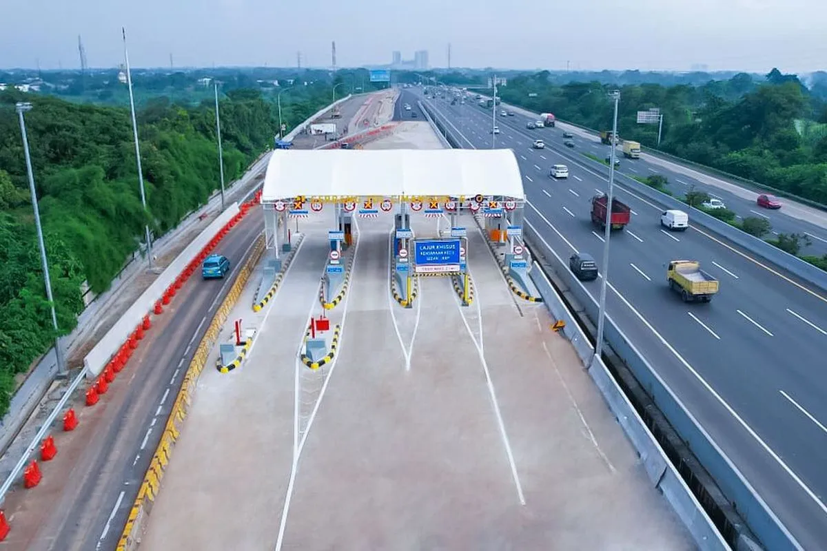 Gerbang Tol Bogor yang ramai dengan kendaraan melintas, menunjukkan jalur keluar masuk tol yang modern dan terawat baik, dengan latar belakang pemandangan perbukitan hijau Bogor.