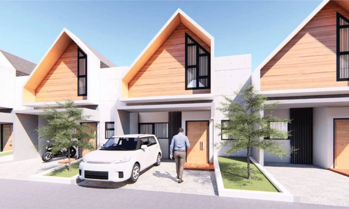 Pasangan muda sedang melihat denah rumah di kantor pemasaran pengembang perumahan baru di Bogor, dengan latar belakang maket perumahan