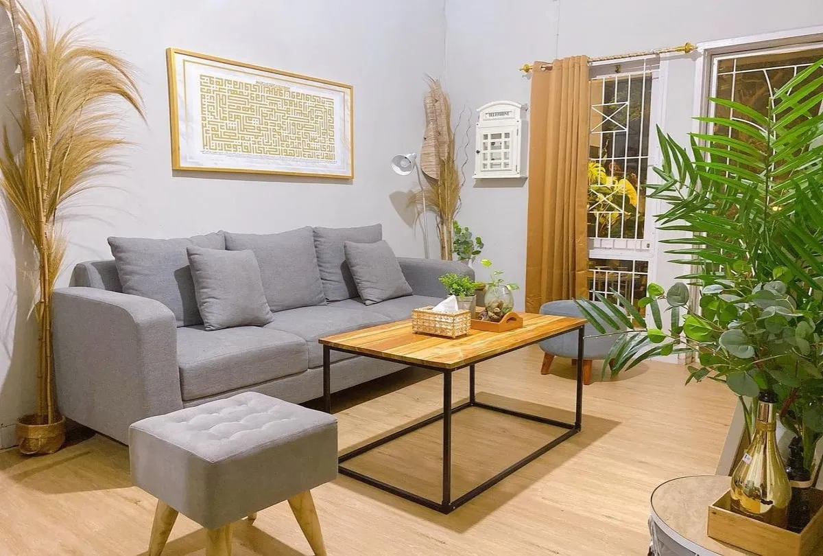 Interior ruang tamu bersama rumah kost yang nyaman dengan sofa, meja, dan dekorasi dinding